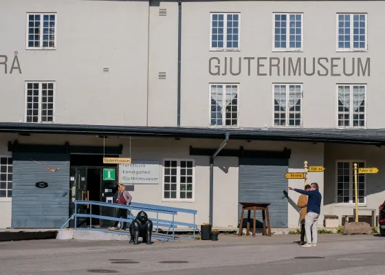 Gjuterimuseets entré vid Hälleforsnäs bruk med en ramp och skulptur framför fasaden.